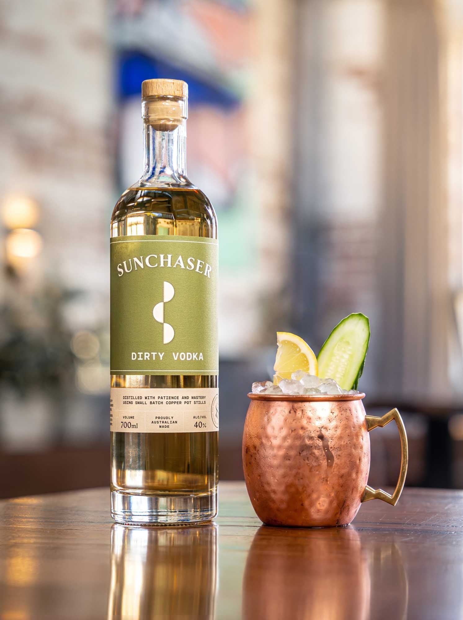 A Dirty Mule in a copper mug with lime, next to a bottle of Sunchaser Dirty Vodka.